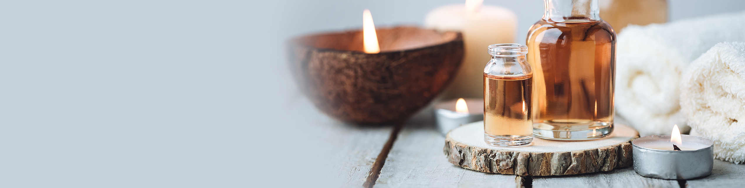Concept of spa treatment in salon with pure organic natural oil. Atmosphere of relax, detention. Aromatherapy, candles, towel, wooden background. Skin care, body gentle treatment