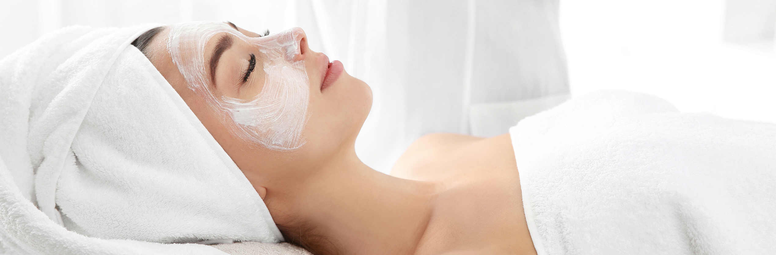 Pretty woman with mask on her face in spa salon. Banner design