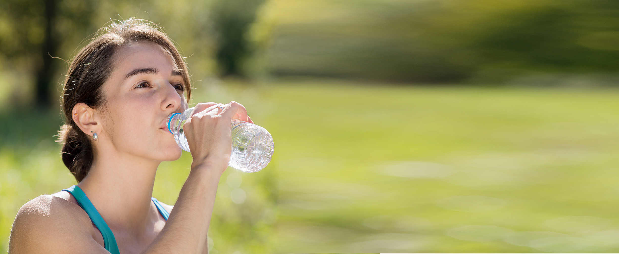 athletic girl drinking water after exercising